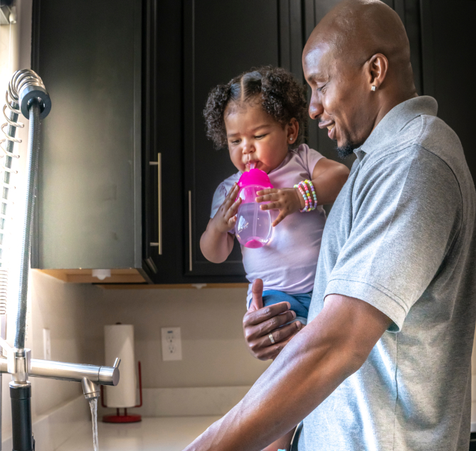A dad holding his daughter in the kitchen